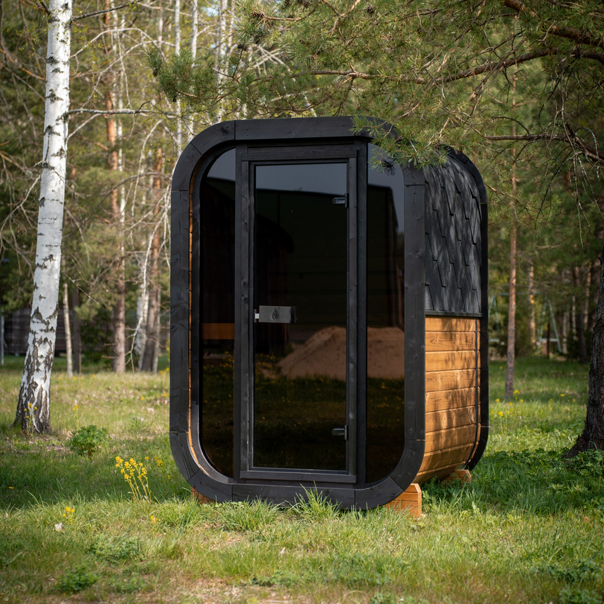 PlusLife Mini Traditional Sauna 2.0 in a dark charcoal finish with a black shingled roof, a full-height dark glass door and a warm timber side panel
